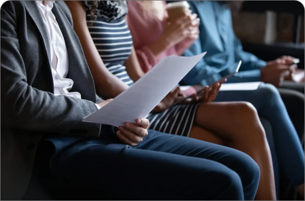 People sitting in a row, holding papers